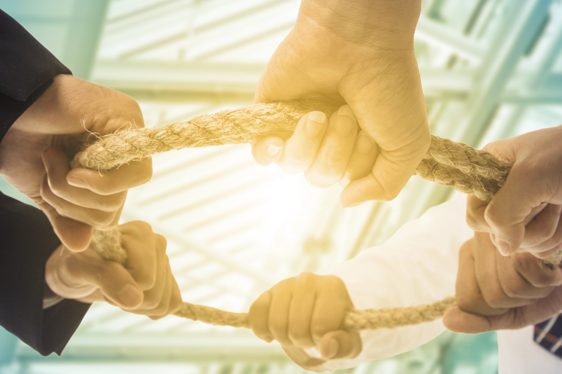 Viele Hände zeihen an einem Ring